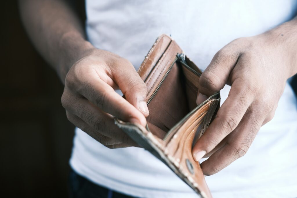 man hands holding an empty wallet. Man thinks how to budget when you’re broke