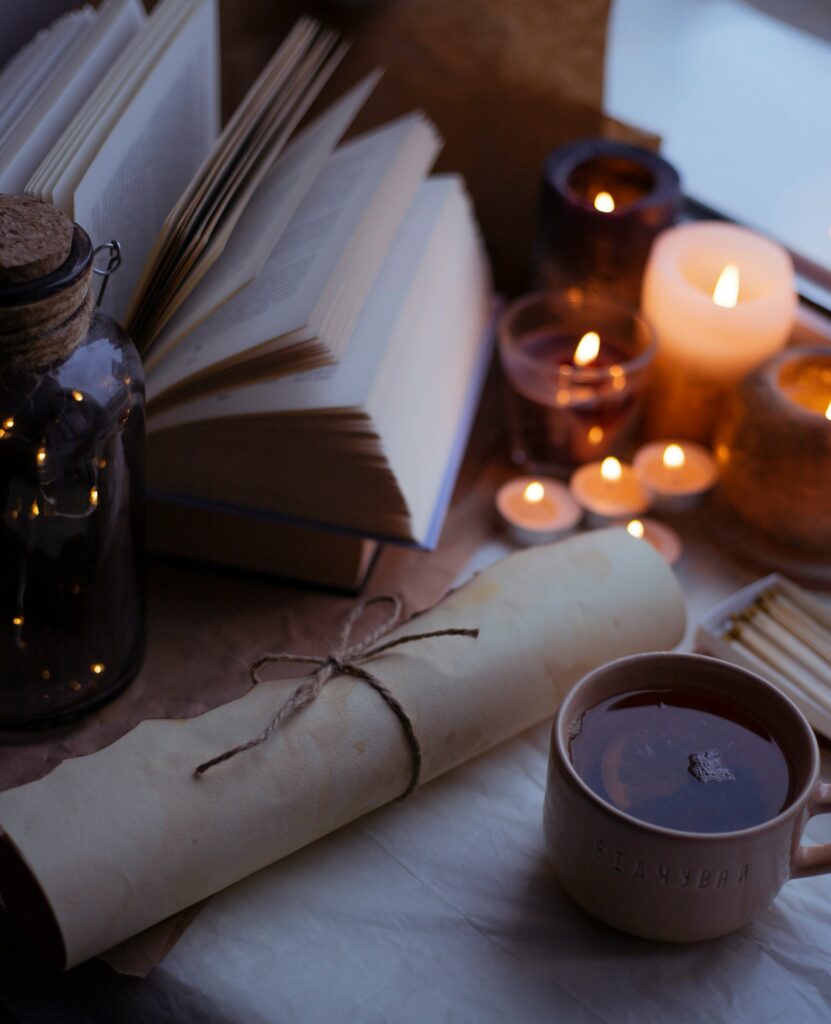A cozy setup with candles, a book, and a rolled letter, symbolizing calm and reflection before bed.