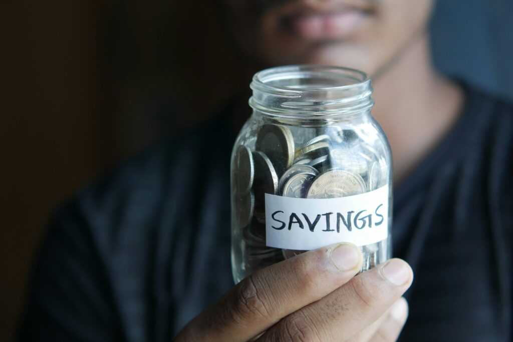 A man holding a jar of euro savings, symbolizing small steps toward financial security.